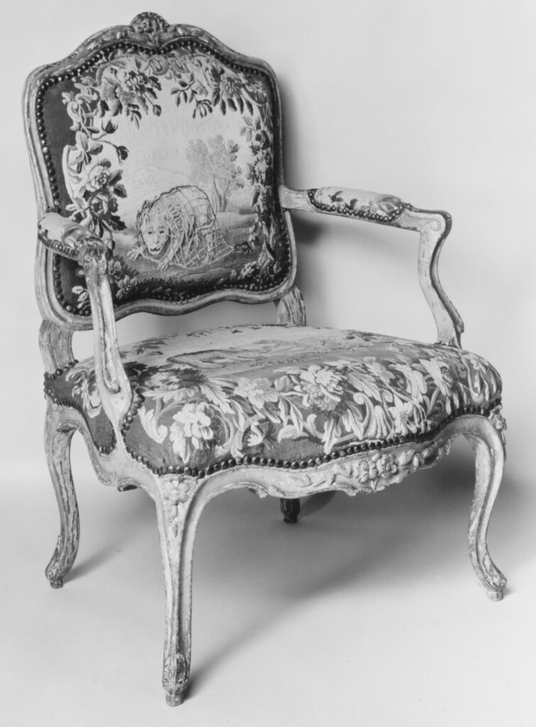 an armchair with an unidentifiable beast depicted on the back cushion