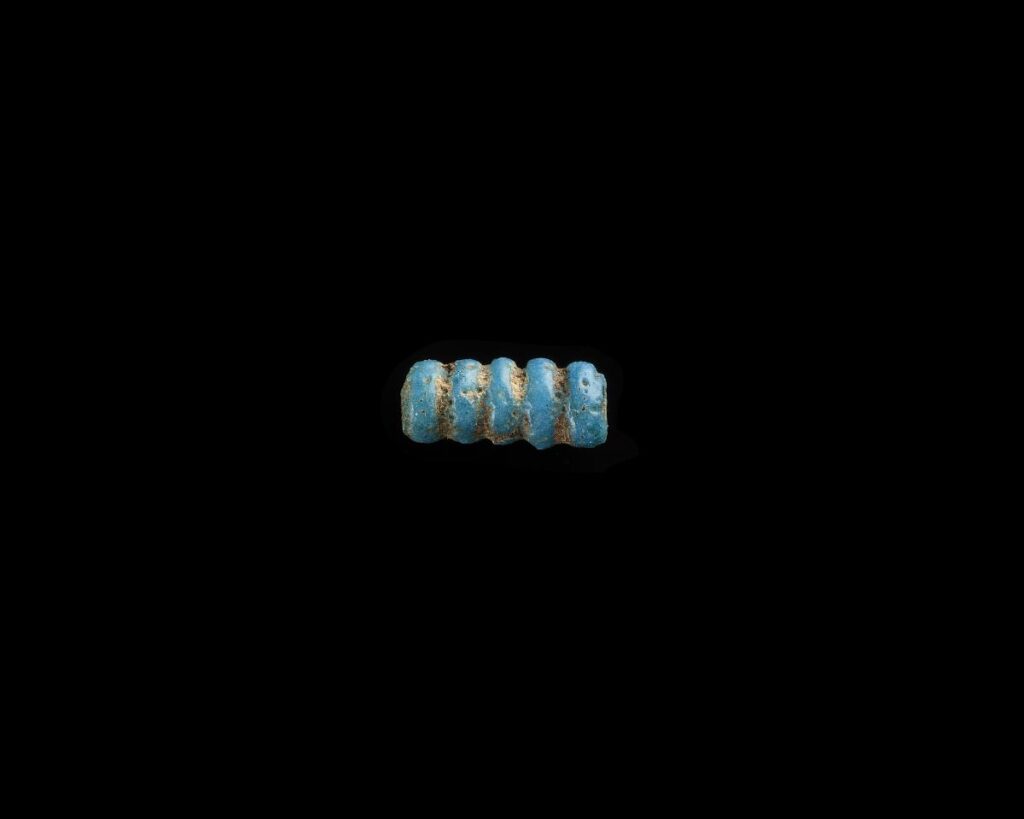 a blue and gold bead on a black background